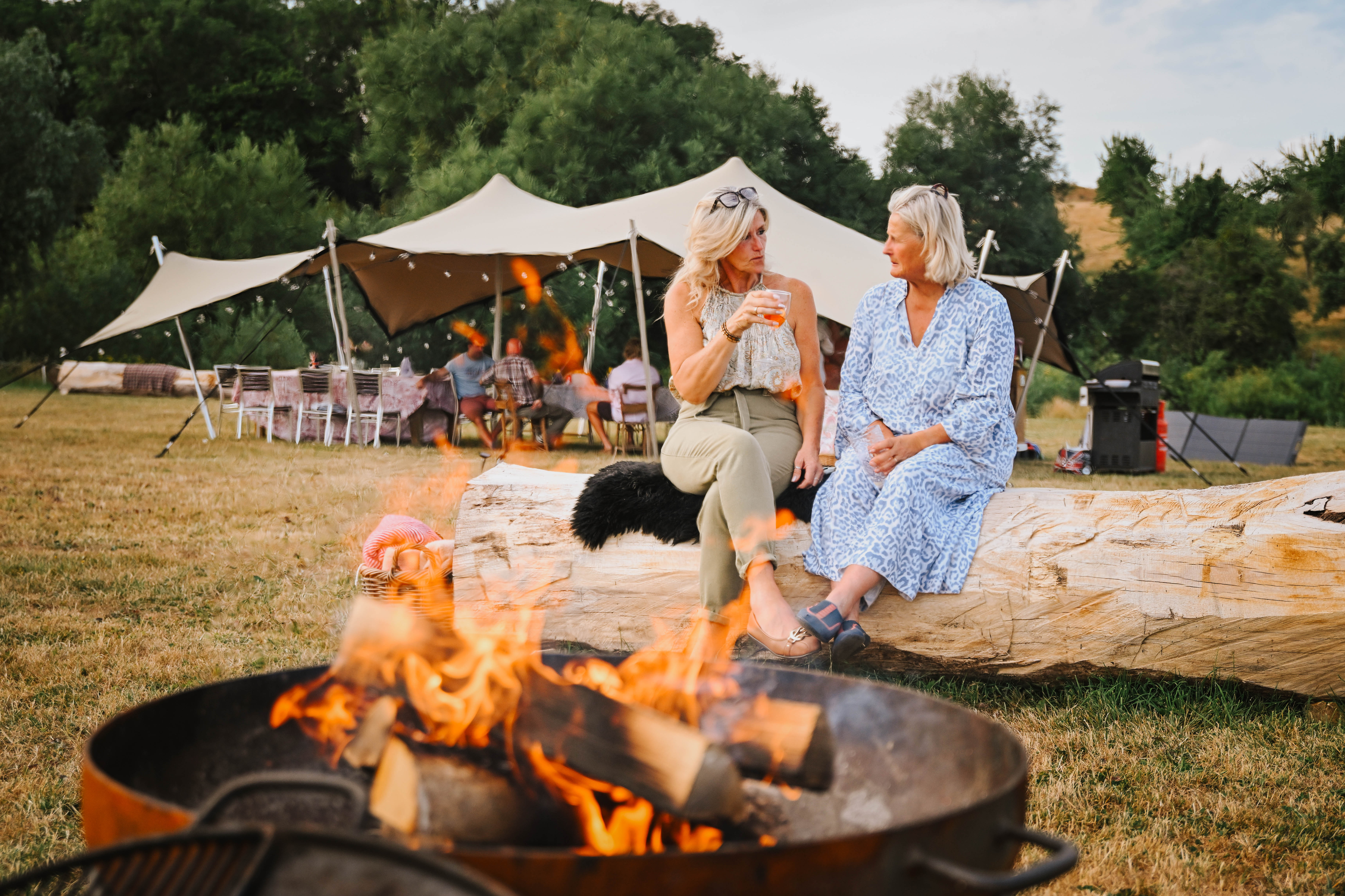 Guests relaxing by the fire at Hopnest Bell Tent Retreat, Worcestershire